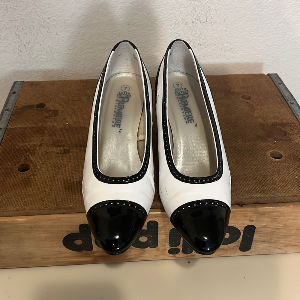 Black and white heels with an eyelet design along the heel and toe.